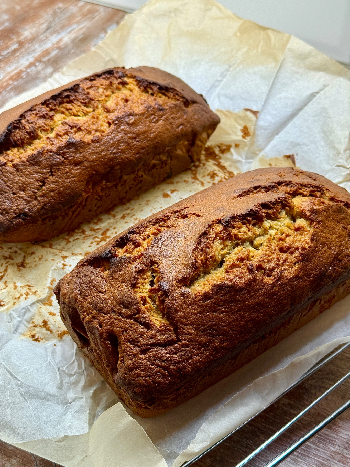 Two freshly baked loaves of banana bread on parchment paper