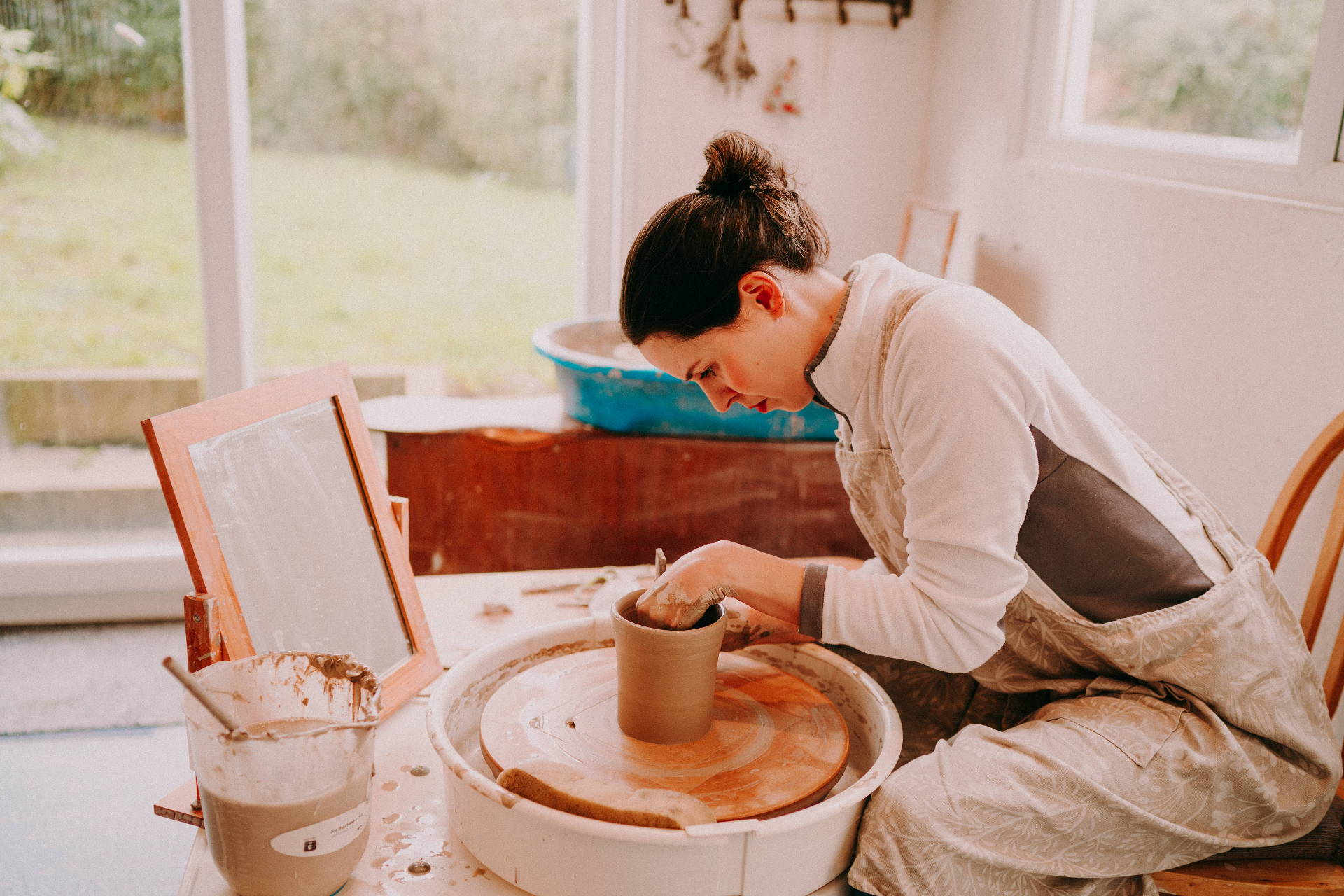 Rachel throwing a pot at a pottery wheel
